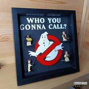 Cadre noir en bois avec les figurines de l'équipe de Ghostbusters avec le logo du fantôme au milieu